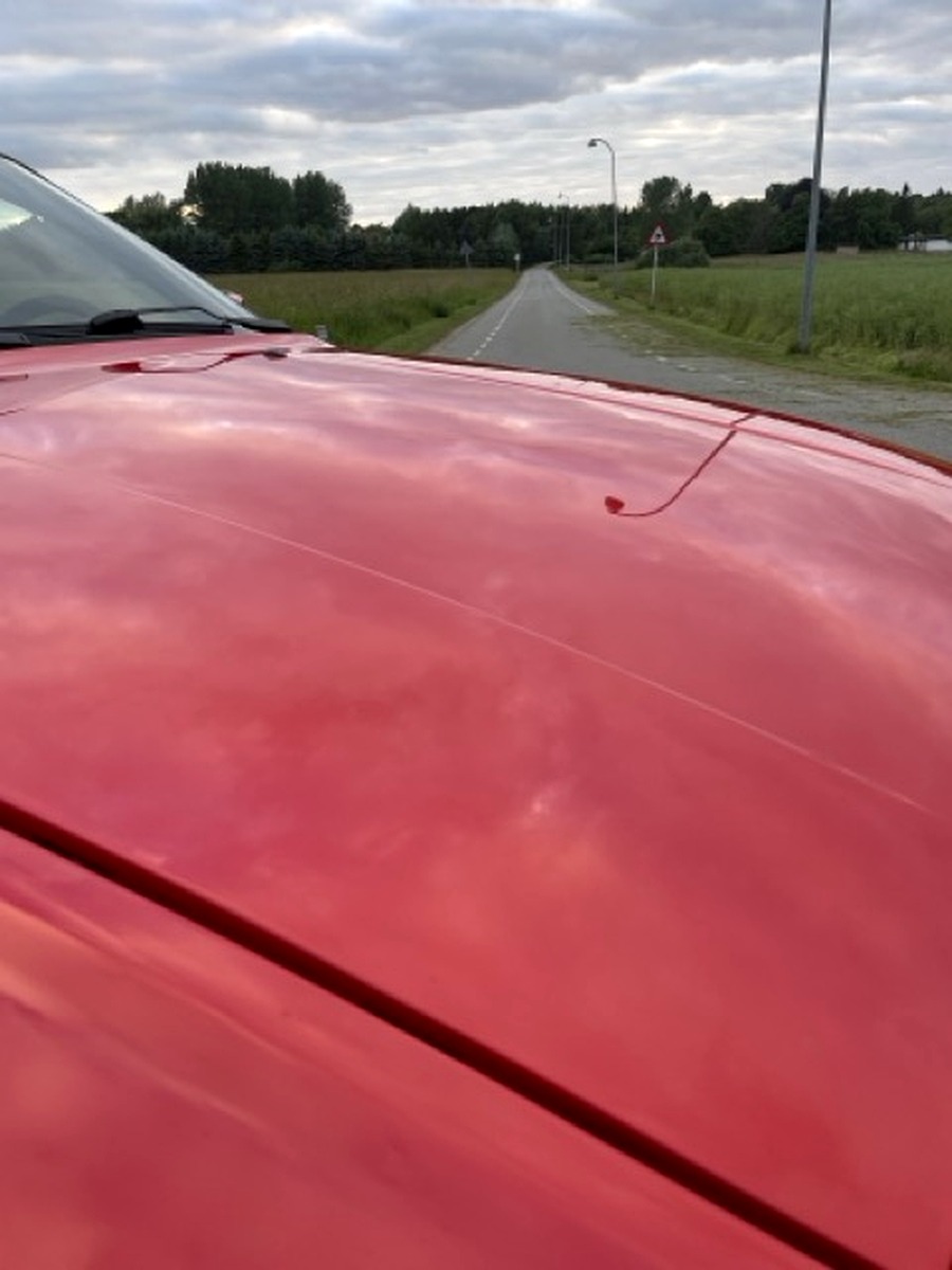 Close-up af rød Porsche-motorhjelm – overflade klar til polering